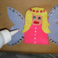 place spots of glue on fingerpuppet fairy
