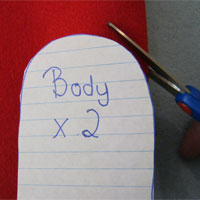 cut out the felt body for the father christmas finger puppet using your scissors